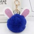 Detailed close-up of blue plush ball keychain with glitter bunny ears and gold lobster clasp - Gold Key Chain Style / Royal Blue