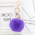 Detailed close-up of purple faux fur pompom keychain with colorful unicorn leather patch - Purple