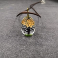 Detalle del colgante ovalado de resina con flores secas naranjas y silueta de árbol - Estilo árbol - Naranja