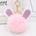 Close-up of pink faux fur pompom keychain with sequin bunny ears and golden clasp - Gold Key Chain Style / Light Pink