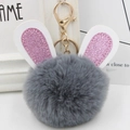 Detail of plush grey bunny ears pom-pom keychain with shimmering pink glitter accents - Gold Key Chain Style / Dark Gray
