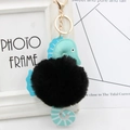 Nahaufnahme von Seepferdchen-Schlüsselanhänger aus blauem Leder mit flauschigem schwarzem Pelz - Goldener Schlüsselketten-Stil / Schwarz