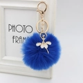 Detail view of royal blue fluffy faux fur ball keychain with golden ballet dancer charm - 8cm Faux Fur / Sapphire Blue