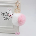 Dettaglio del portachiavi in peluche di alpaca rosa con moschettone dorato su cornice - 8cm Pelliccia di Coniglio Sintetica / Bianco + Rosa