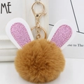 Macro detail of brown plush rabbit fur ball keychain with pink glitter ears and gold clasp - Gold Key Chain Style / Coffee