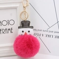 Gros plan d'un porte-clés bonhomme de neige rose avec petit chapeau noir et fermoir doré - Rouge Rose