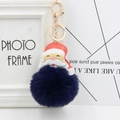 Detailed shot of navy blue faux fur pompom keychain with stitched Santa leather pendant - Navy Blue