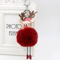 Close-up of reindeer plush charm with fluffy red faux fur pompom and festive hat - Burgundy