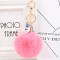 Close-up of fluffy pink pompom keychain with gold hardware and unicorn charm - Deep Pink