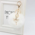 Detail of a white fluffy pompom keychain featuring a rhinestone ballerina and gold clasp - 8cm Faux Fur / White