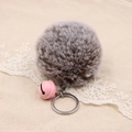 Detailed macro view of soft grey faux fur pompom and pink metal bell keychain - 8cm Faux Rabbit Fur With Bell / Two-tone Grey
