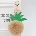 Detail of pineapple faux fur pom-pom keychain with green PU leaves and gold lobster clasp - 8cm / Khaki