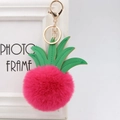 Close-up of pink pineapple fur pompom keychain with green faux leather leaves - 8cm / Rose Red