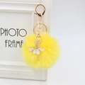 Detail of yellow plush pompom keychain with a sparkling rhinestone ballerina pendant - 8cm Faux Fur / Yellow