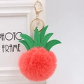 Detail of red faux fur pineapple keychain with green leather leaves and golden metal hook - 8cm / Orange