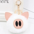 Close-up of white plush pig keychain with pink leather ears and gold metal clasp - Gold Key Chain Style / White
