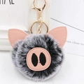 Close-up of cute pig plush keychain with grey faux fur and pink leather details - Gold Key Chain Style / Two-tone Black