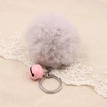 Close-up of soft grey plush ball keychain with pink bell on beige linen background - 8cm Faux Rabbit Fur With Bell / Light Gray