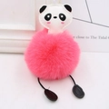 Close-up of cute panda plush keychain with rose red faux fur pompom and cartoon leather head - Watermelon red