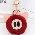 Close-up of fluffy red faux fur pig keychain with pink leather ears and gold metal clasp - Gold Key Chain Style / Burgundy