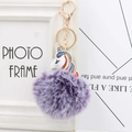 Detail of purple faux fur pompom keychain with a rainbow unicorn and gold metal clasp - Two-tone Purple