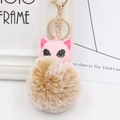Gros plan sur breloque chat en cuir rose avec pompon beige et porte-clés doré - Khaki mélangé