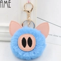 Close-up of light blue plush pig keychain with soft faux fur and golden metal ring - Gold Key Chain Style / Light Blue