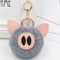 Detailed macro view of the cute grey plush pig keychain with soft faux fur and pink ears - Gold Key Chain Style / Dark Gray