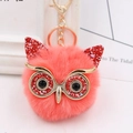 Close-up of pink faux fur owl keychain with red sequins and golden metallic accents - Gold Key Chain Style / Orange Red