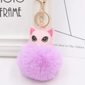 Vue détaillée du pompon en fourrure violette et du porte-clés tête de chat en cuir rose - Violet Taro