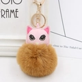 Détail d'un pendentif chat en cuir PU rose avec pompon marron et porte-clés doré - Café