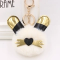 Gros plan du porte-clés lapin en peluche blanche avec oreilles noires et dorées - Blanc Cassé