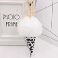Close-up of leopard print ice cream keychain with fluffy white faux fur pompom and gold clasp - Gold Key Chain Style / White