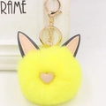 Vue macro du porte-clés en fausse fourrure jaune avec oreilles de chat et cœur rose - Style Chaîne De Clé Or / Jaune