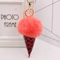 Close-up of fluffy pink faux fur ice cream keychain with a stylish leopard print cone - Gold Key Chain Style / Orange Red
