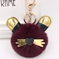Détail du porte-clés en peluche bordeaux avec oreilles dorées et fermoir en métal doré - Fuchsia