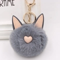 Gros plan d'un porte-clés en peluche gris avec oreilles de chat et détails de cœur - Style Chaîne De Clé Or / Gris clair