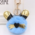 Détail d'un porte-clés pompon en peluche bleu ciel avec des oreilles de lapin dorées - Bleu clair