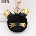 Gros plan du porte-clés chat en peluche noir avec oreilles dorées et fermoir - Noir