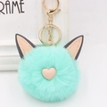 Gros plan du porte-clés en peluche vert menthe avec oreilles de chat et détail de cœur rose - Style Chaîne De Clé Or / Vert menthe