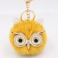 Close-up of fluffy yellow owl keychain with golden sequins and polished metal lobster clasp - Gold Key Chain Style / Orange Yellow White