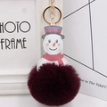 Macro detail of plush snowman keychain with burgundy faux fur ball and gold metal hardware - Fuschia