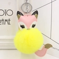 Detail of cute fox plush keychain featuring yellow fur ball and pink faux leather accents - Silver Keyring / Yellow