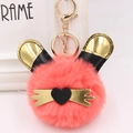 Détail d'un porte-clés lapin en peluche rose avec oreilles dorées et cœur noir - Rouge Orangé