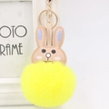 Detail of yellow plush pompom bunny keychain with beige leather ears and golden metal clasp - Yellow