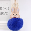 Close-up of cute rabbit plush keychain with deep blue pom-pom and gold hardware - Sapphire Blue