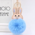 Detail of cute blue rabbit plush keychain with soft faux fur pompom and golden ring - Light Blue