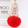 Detail of red faux fur pompom keychain with pink rabbit ears and golden clasp for bags - Red