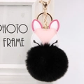 Detail of pink and white fox pendant with large black fluffy fur pom pom on gold lobster clasp - Black