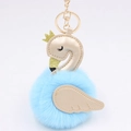Macro detail of swan plush keychain with faux leather wings and golden crown decoration - Blue-Champagne